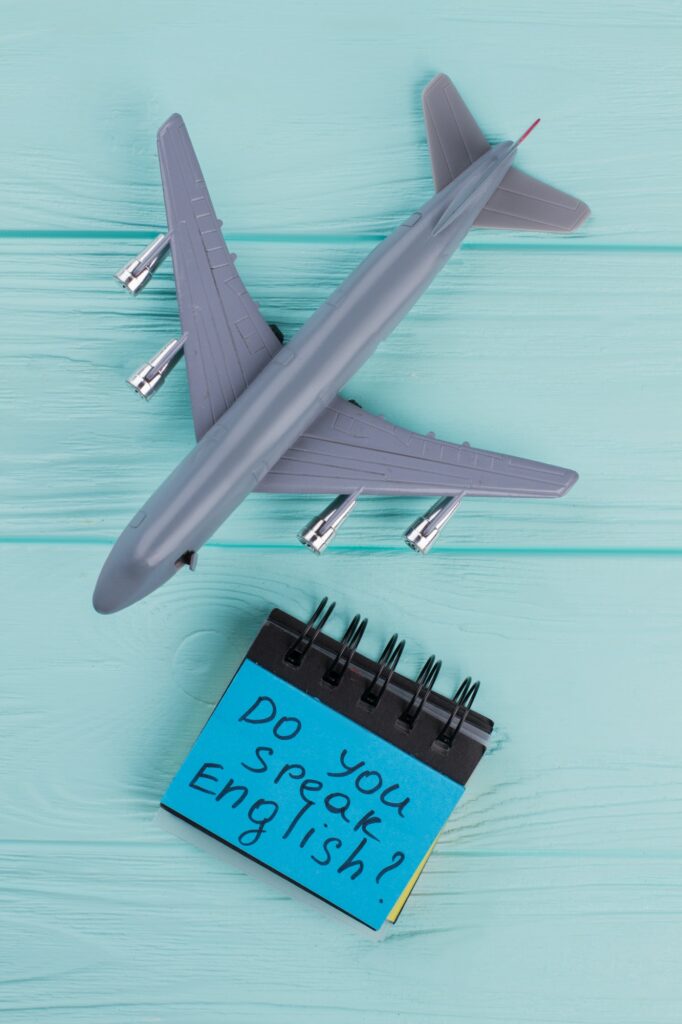 Plastic toy passenger jet plane and sticky paper on blue wooden background.